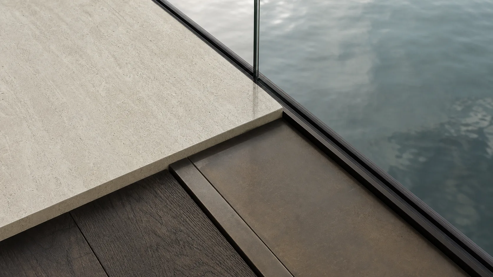 Directional material study of stone and dark timber beside water